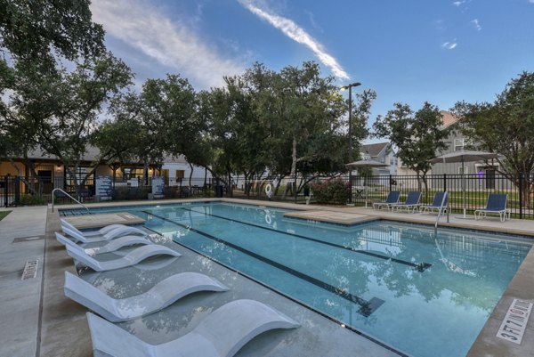 Outdoor pool at Farm Haus Luxury Rental Homes Apartments with comfortable lounge chairs and sun umbrellas