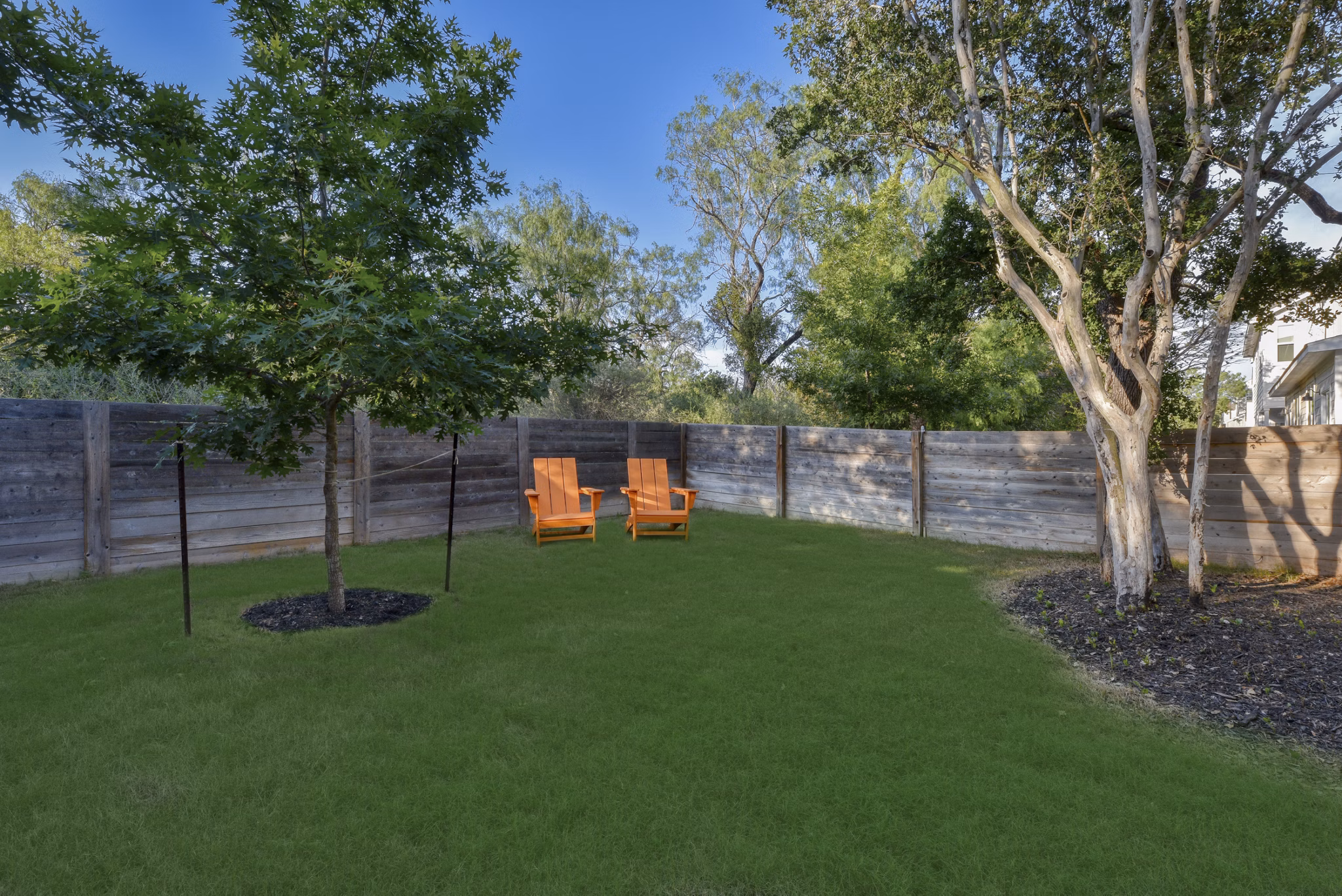 Courtyard with lush greenery and seating at Farm Haus Luxury Rental Homes