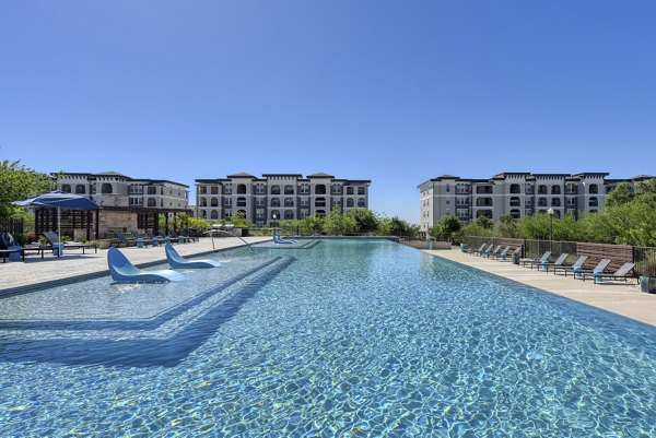 Resort-style pool at The View at TPC Apartments featuring lush landscaping and ample lounge seating