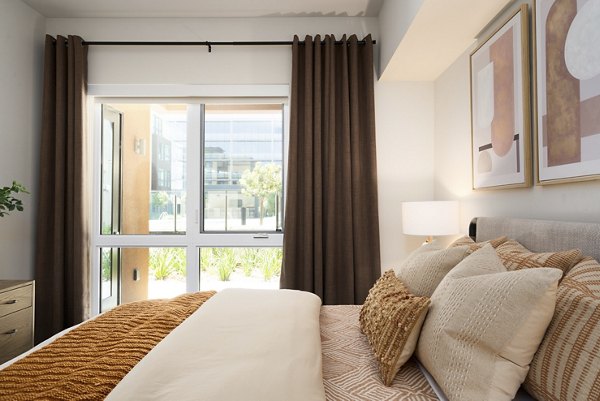 Modern bedroom with stylish decor and large windows at Rowe at Pear Village Apartments