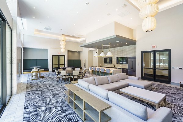 Modern clubhouse featuring a cozy lounge and entertainment area at Rowe at Pear Village Apartments