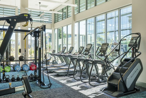 Modern fitness center with cardio and strength equipment at Rowe at Pear Village Apartments