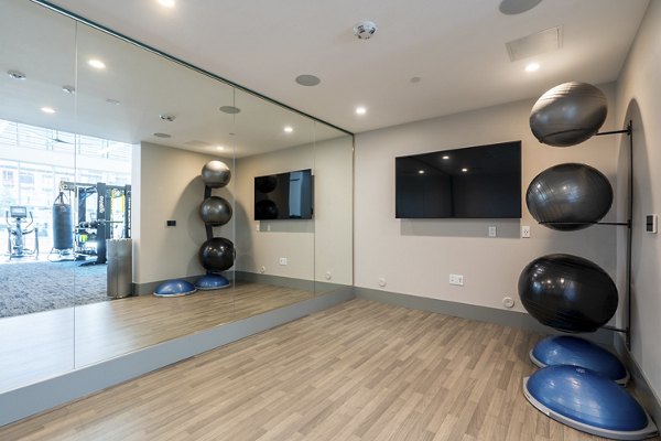 Sunlit yoga studio with wood flooring at Rowe at Pear Village Apartments