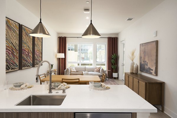 Modern kitchen with stainless steel appliances and marble countertops in Rowe at Pear Village Apartments