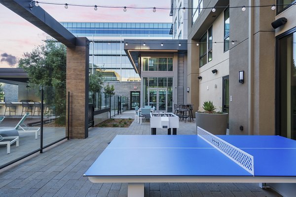 Charming patio recreational area with seating and lush greenery at Rowe at Pear Village Apartments