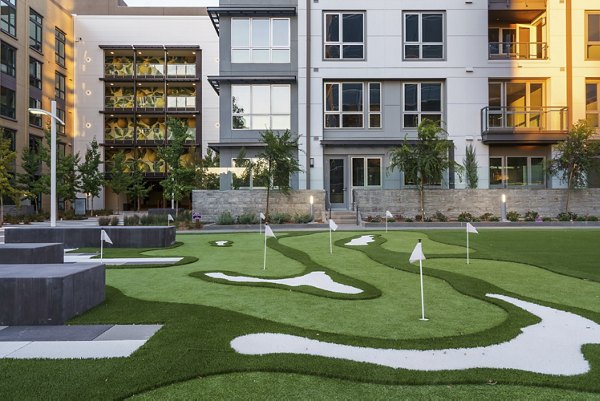 Putting green with manicured lawn at Rowe at Pear Village Apartments, luxury community feature for residents' leisure