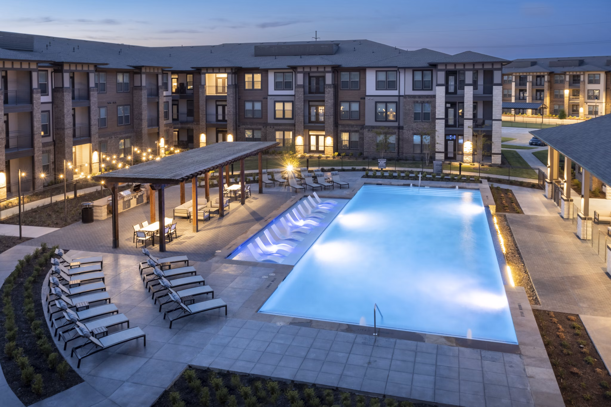Resort-style swimming pool at Union House Apartments with luxury seating and lush landscaping