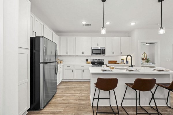 Modern kitchen with stainless steel appliances and granite countertops at Evermore Apartments