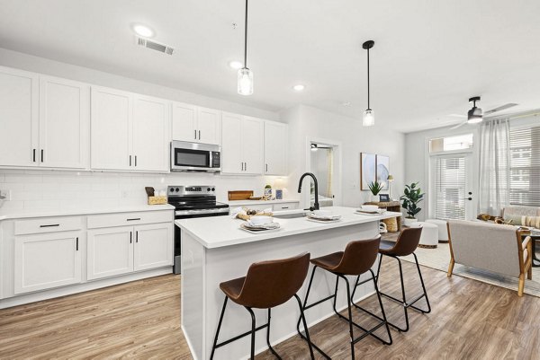 Modern kitchen with island and stainless steel appliances in Evermore Apartments