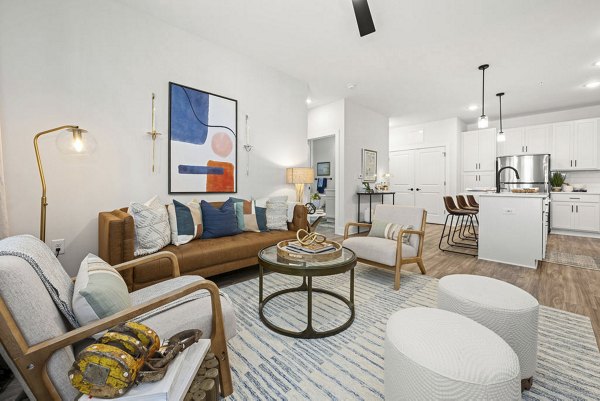 Spacious living room with modern decor and large windows in Evermore Apartments, a luxury community