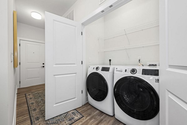 Laundry room with modern appliances at Evermore Apartments