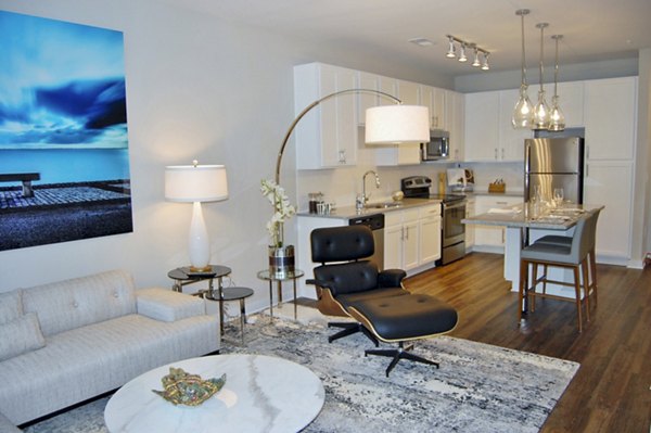 Spacious living room with stylish furniture and large windows in 5115 Park Place Apartments