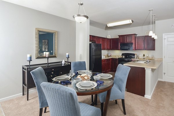 Modern dining room with elegant chandelier at 62 Eleven Apartments, featuring stylish decor and ample natural light