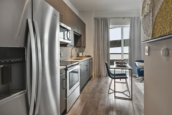 Modern kitchen with stainless steel appliances at 675 N Highland Apartments