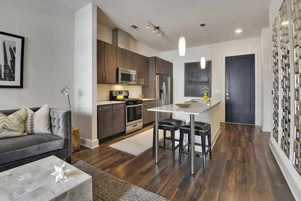 Modern kitchen featuring stainless steel appliances and marble countertops at 675 N Highland Apartments