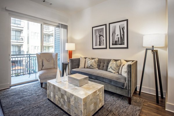 Spacious living room with modern decor and natural light in 675 N Highland Apartments, a Greystar luxury property in desirable location