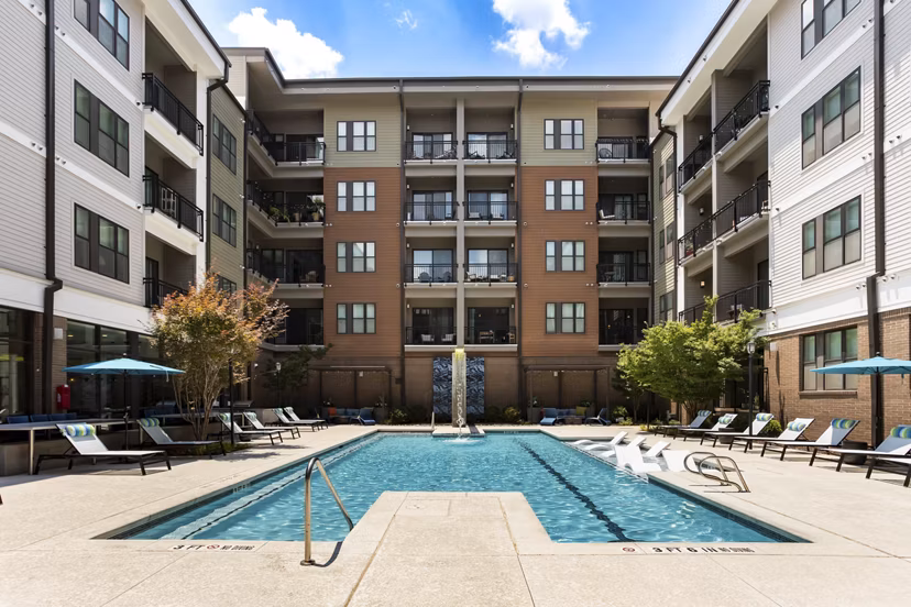 Sparkling pool with sun loungers at 675 N Highland Apartments, a Greystar luxury community