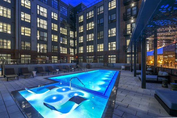 Refreshing outdoor pool at Alta 801 Apartments featuring luxurious lounge chairs and elegant landscaping