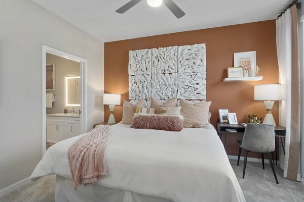 Bedroom with stylish decor and large windows at Alta 99th Ave Apartments