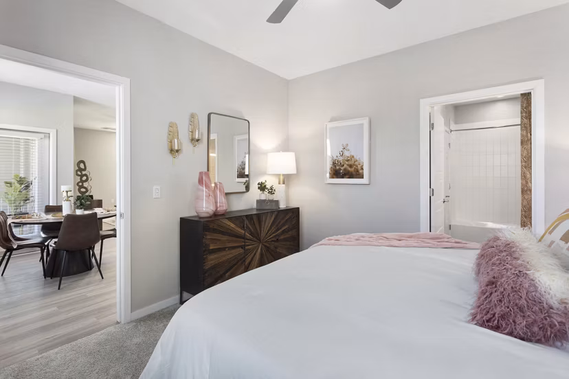 Bedroom with modern decor at Alta 99th Ave Apartments featuring plush bedding and natural light