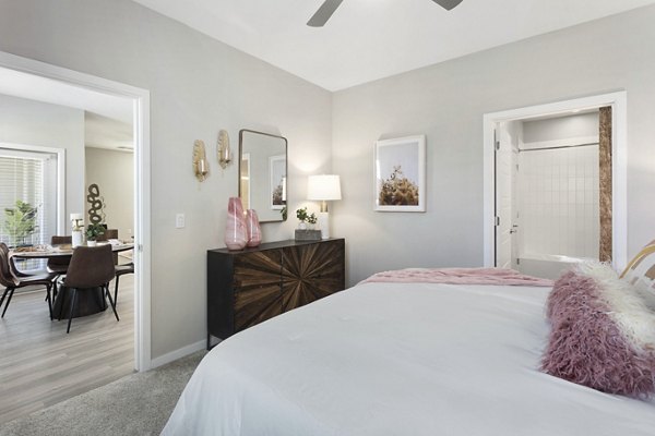 Bedroom with modern decor at Alta 99th Ave Apartments featuring plush bedding and natural light