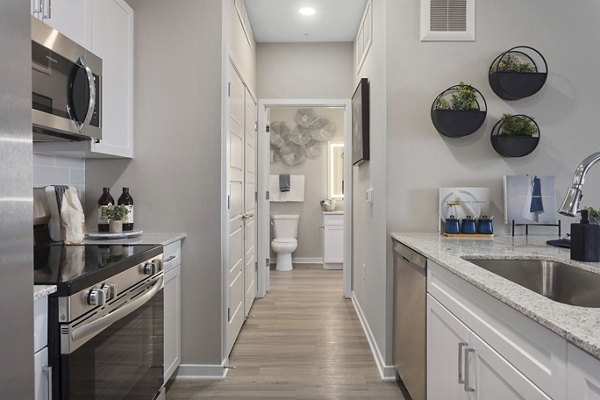 Modern kitchen featuring stainless steel appliances and granite countertops at Alta 99th Ave Apartments