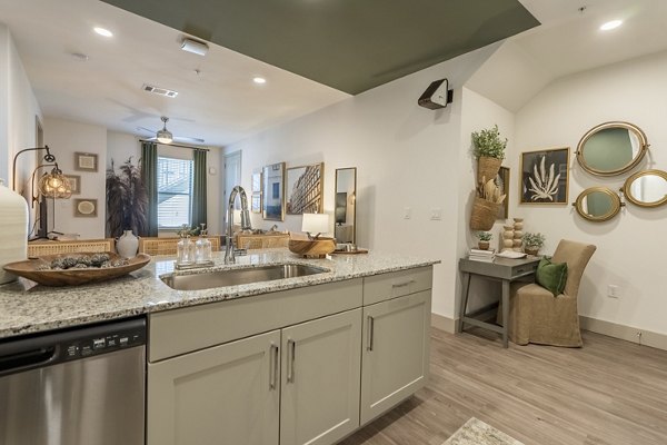 Modern kitchen featuring stainless steel appliances and granite countertops in Alta Berry Creek Apartments