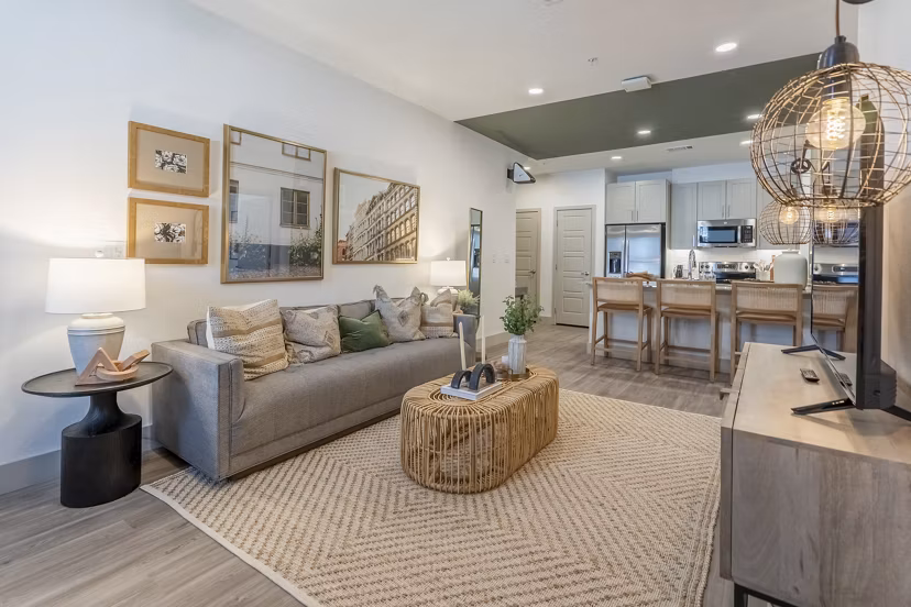 Modern living room with sleek furniture and large windows at Alta Berry Creek Apartments