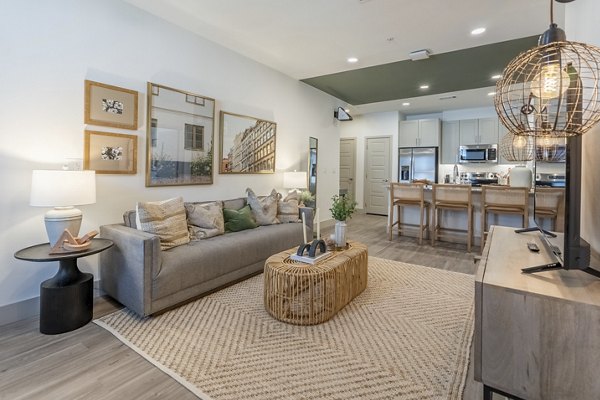 Modern living room with sleek furniture and large windows at Alta Berry Creek Apartments