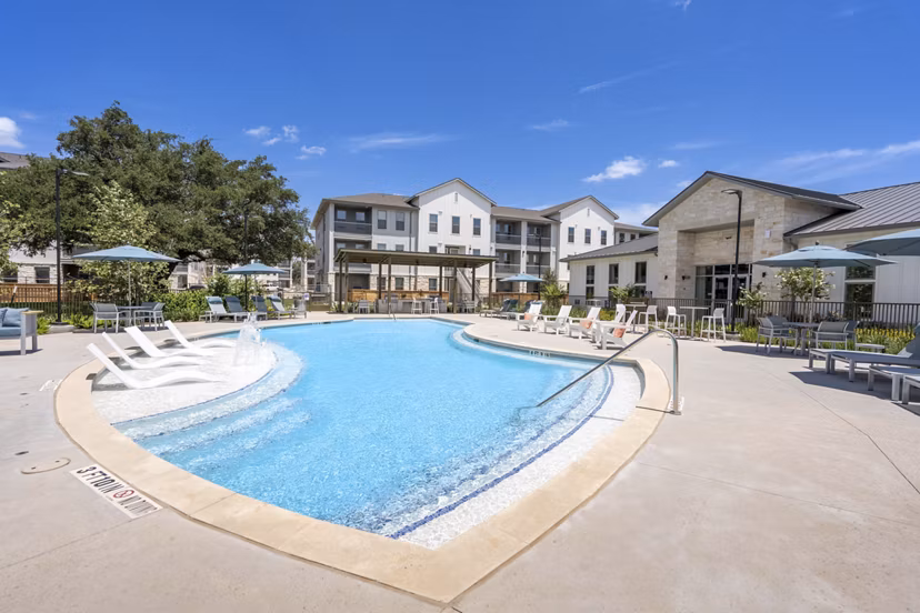 Luxurious outdoor pool at Alta Berry Creek Apartments with elegant poolside seating area