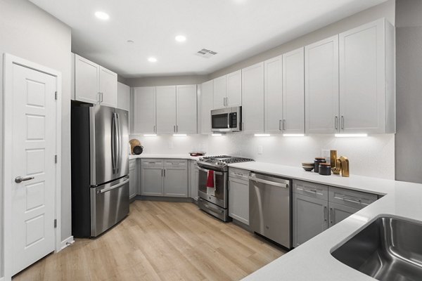 Modern kitchen with stainless steel appliances and white cabinets at luxury apartments