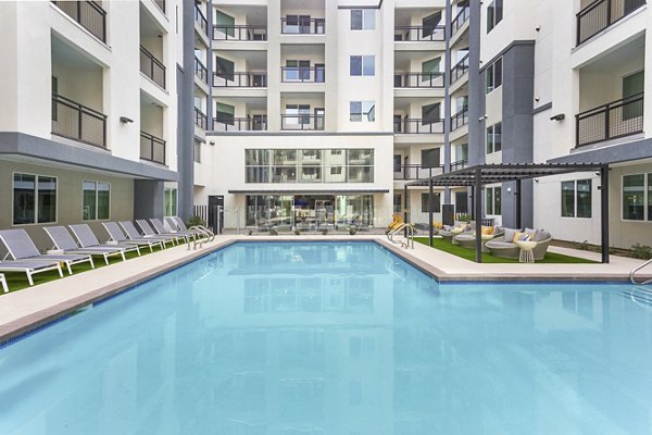 Resort-style pool with palm trees at Alta Biltmore Apartments, offering luxury outdoor amenities for relaxation and leisure