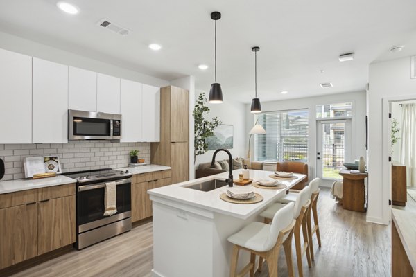 Modern kitchen with stainless steel appliances in Alta City Side Apartments