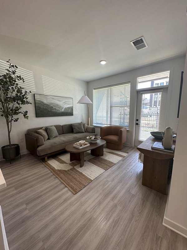 Spacious living room with modern decor at Alta City Side Apartments, featuring elegant furnishings and ample natural light