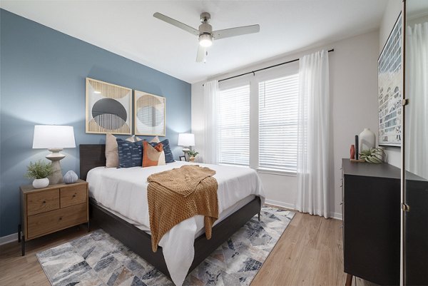 Cozy bedroom featuring a plush bed and modern decor at Alta Citron Apartments, luxury living by Greystar