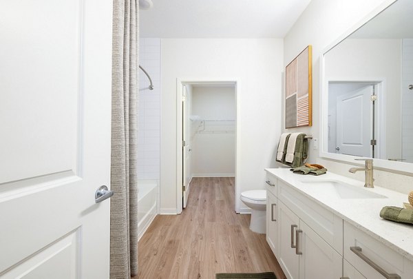 Modern bathroom featuring sleek fixtures and large mirror in Alta Citron Apartments