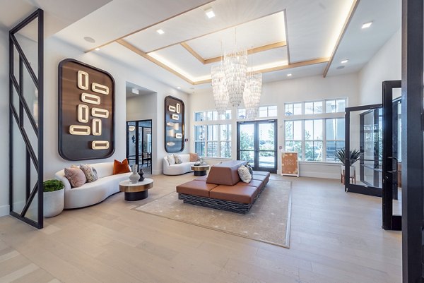Clubroom with modern furnishings and large windows at Alta Citron Apartments, luxury living space in a vibrant community