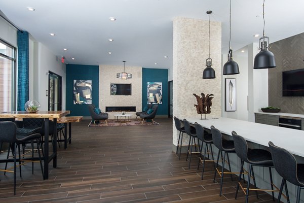 Clubhouse with modern seating and entertainment space at Alta Clara at the Fells Apartments, ideal for social gatherings and relaxation