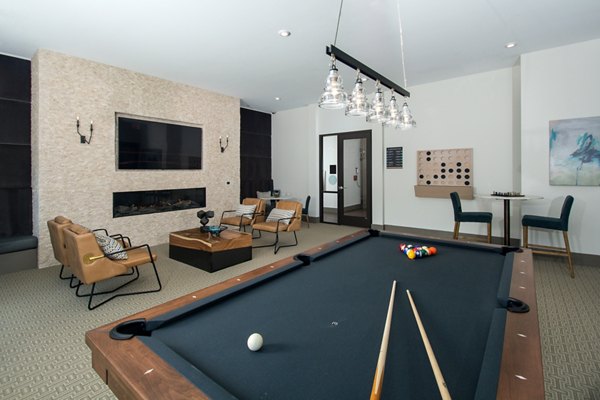 Modern game room featuring billiards and lounge seating at Alta Clara at the Fells Apartments