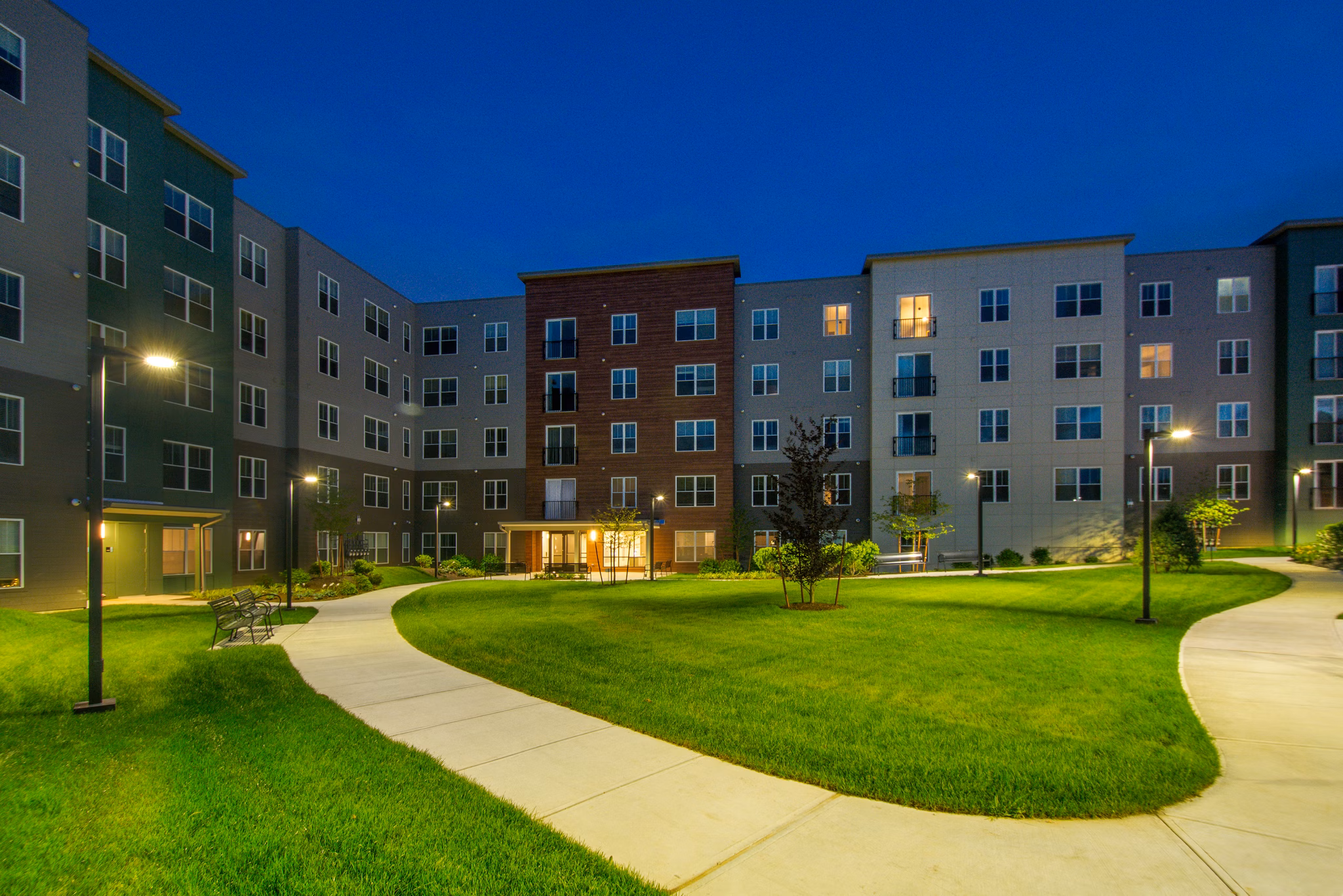 Serene courtyard with lush greenery at Alta Clara at the Fells Apartments