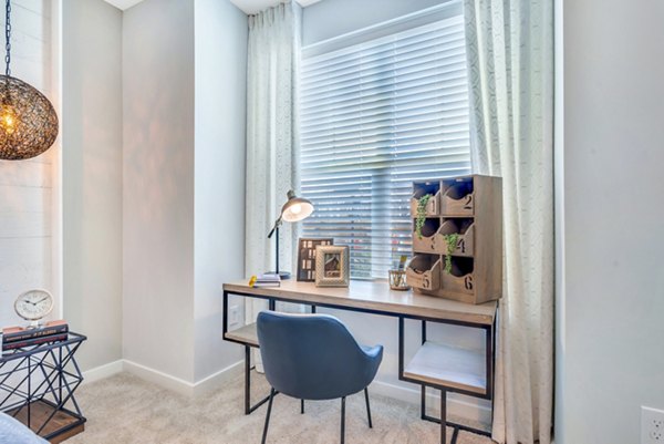 Bedroom with home office setup at Alta Croft Apartments featuring a modern desk and cozy bed