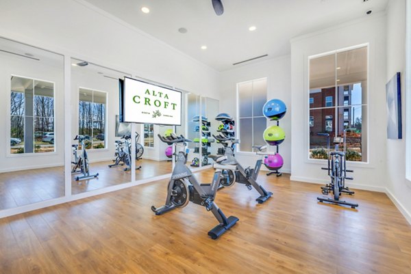 Yoga/spin studio with mirrored walls and stationary bikes at Alta Croft Apartments