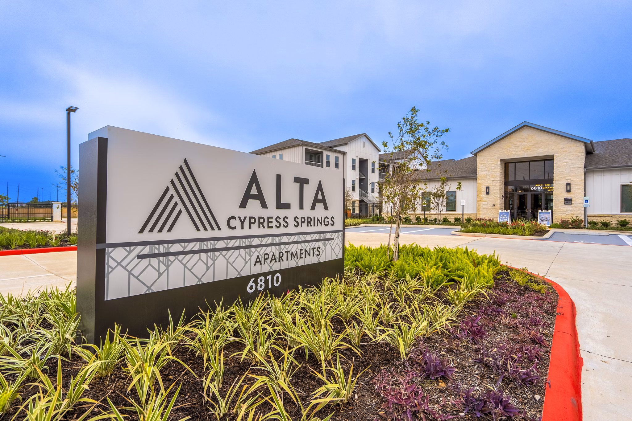 Alta Cypress Springs: Elegant signage at luxury apartments in a serene setting