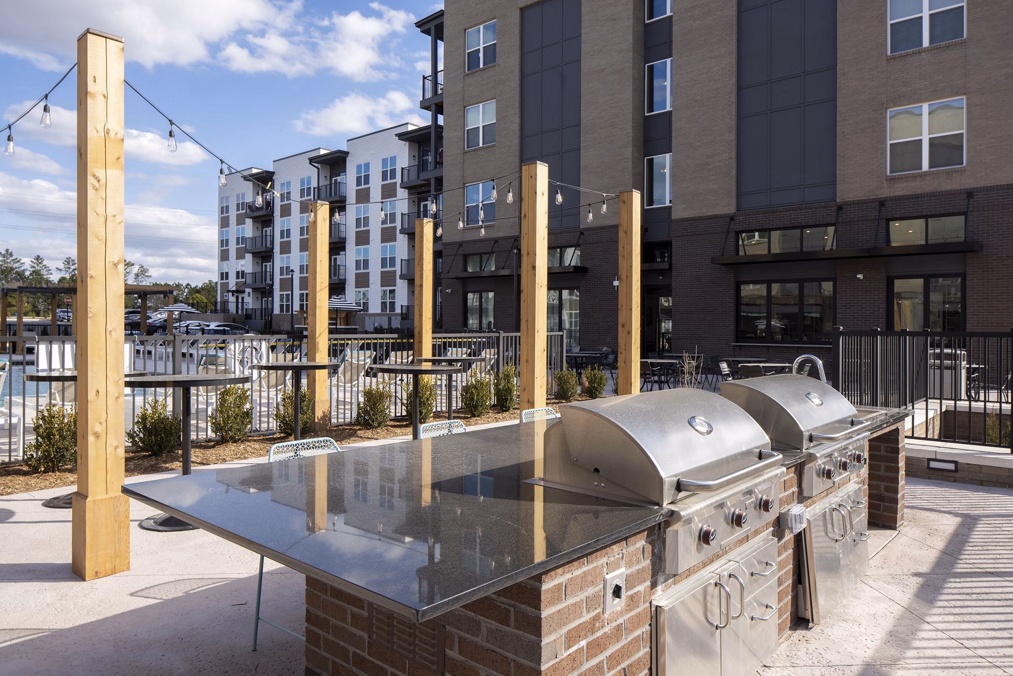 Outdoor grill and patio area at Alta Davis Apartments featuring modern seating for luxury living