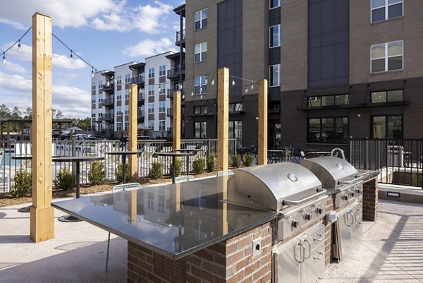 Outdoor grill and patio area at Alta Davis Apartments featuring modern seating for luxury living