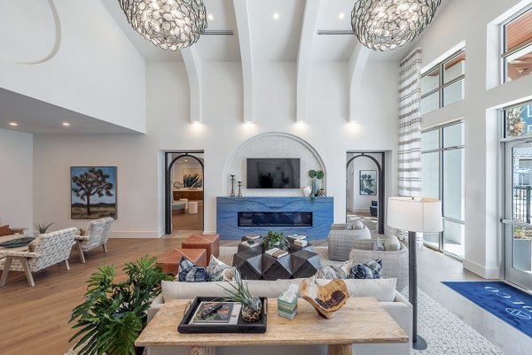 Modern clubhouse with stylish decor and seating areas at Alta Deco Apartments, ideal for gathering and relaxation