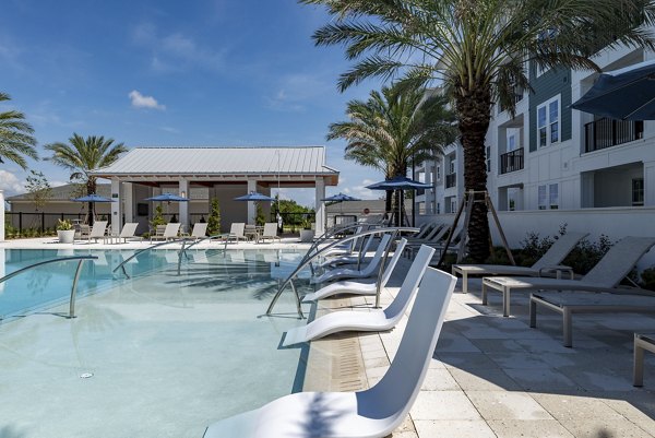 Alta Deco Apartments: Luxurious pool with sleek lounge chairs in a chic urban setting