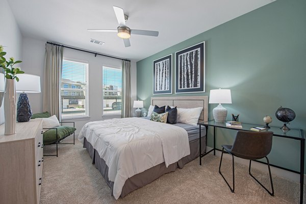 Alta Denton Station Apartments: Cozy bedroom with modern furnishings and ample natural light