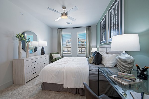 Cozy bedroom with modern decor at Alta Denton Station Apartments, featuring plush bedding and natural light