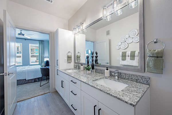 Modern bathroom featuring sleek finishes and ample lighting at Alta Denton Station Apartments